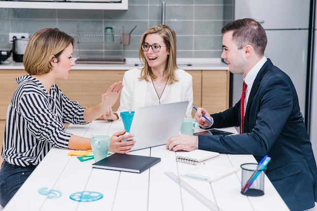 Cheerful colleagues using devices