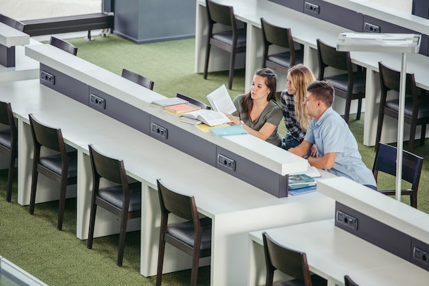 Cheerful college classmates in library