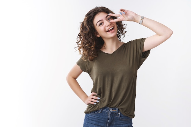 Cheerful confident good-looking young woman have day-off cheering having fun feel lucky upbeat show victory or peace gesture tilt head carefree smiling broadly white teeth, studio background