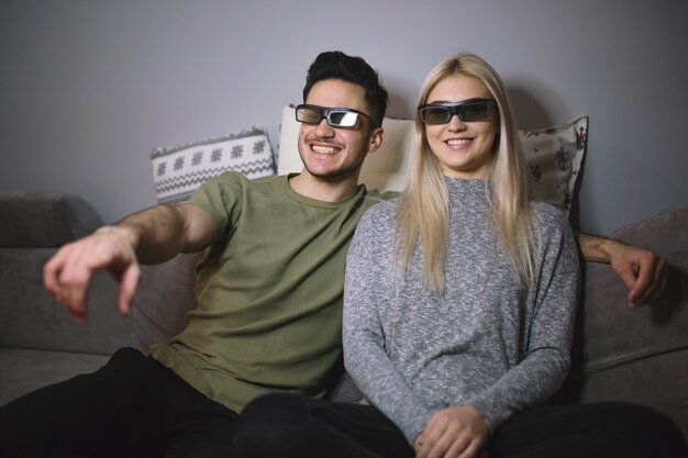 Cheerful couple in 3d glasses watching film