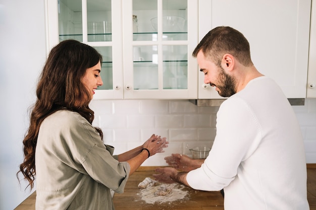 Cheerful couple cooking knead