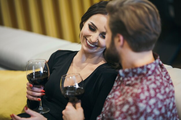 Cheerful couple enjoying wine at home