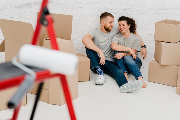 Free photo cheerful couple on floor in new flat