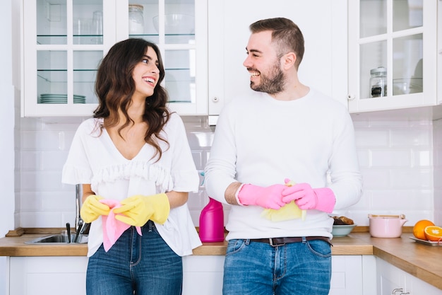Cheerful couple in gloves with sprayer