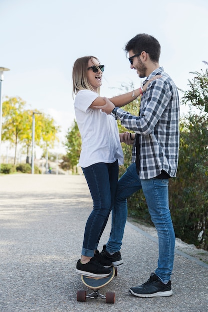 Cheerful couple having fun with longboard