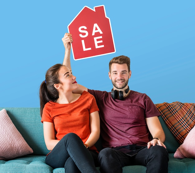 Free photo cheerful couple holding a house sale icon