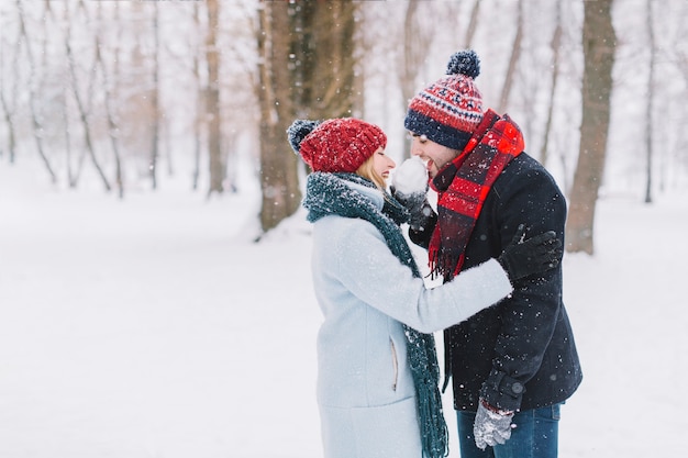 Cheerful couple licking snowball