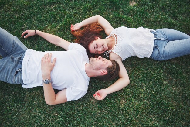 草の上に横たわる陽気なカップル。