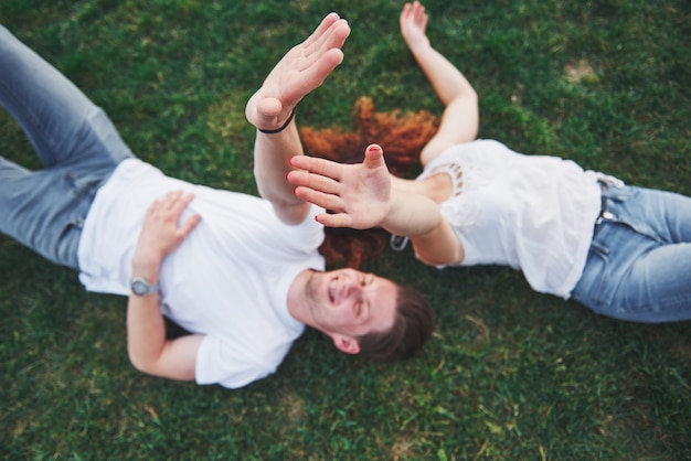 Free photo cheerful couple lying on the grass.