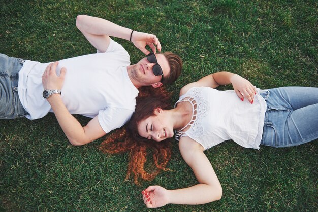 Веселая пара, лежа на траве.