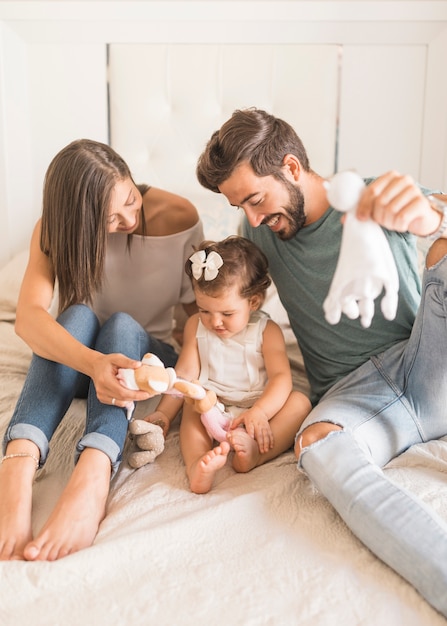 Cheerful couple playing with girl