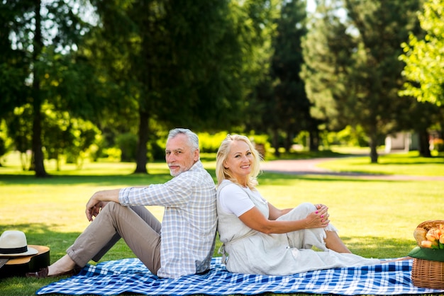 Cheerful couple sitting back to back