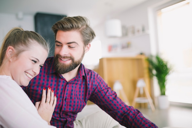 Free photo cheerful couple sitting at home