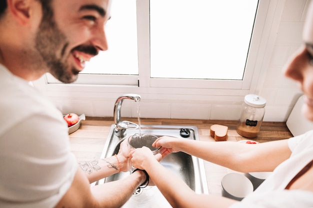 Cheerful couple washing jug