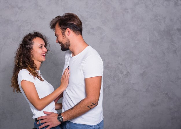 Cheerful couple in white clothes hugging