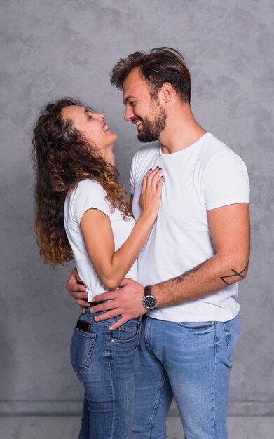 Cheerful couple in white hugging 