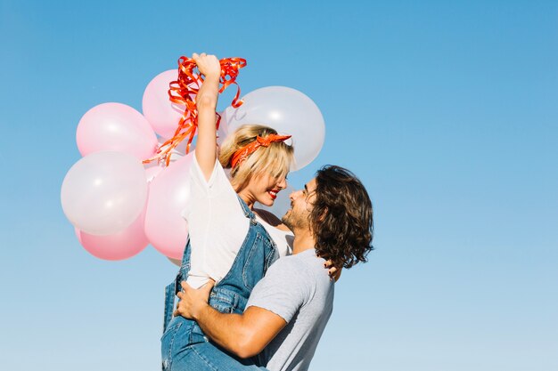 Cheerful couple with bunch of balloons