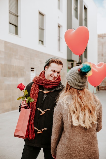 Free photo cheerful couple with gifts on city street