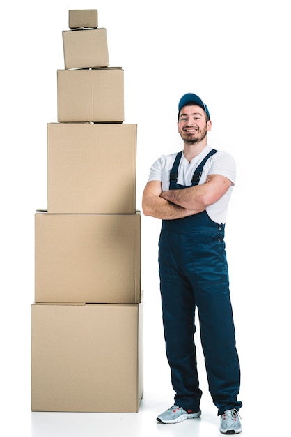 Cheerful courier near stack of boxes