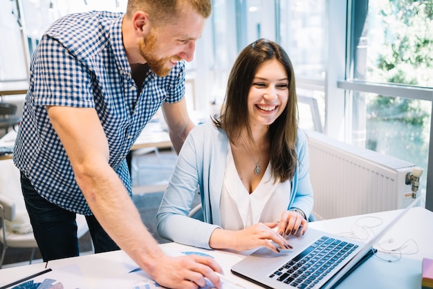 Cheerful coworkers at laptop computer