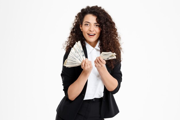 cheerful curly business girl holding money