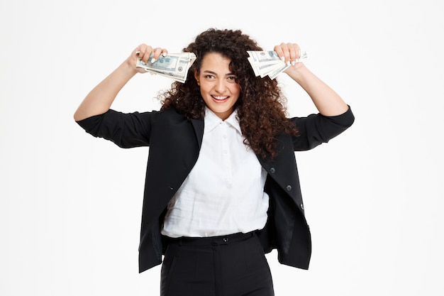 Free photo cheerful curly business girl holding money