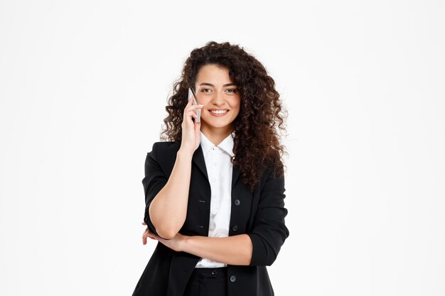  cheerful curly business girl talking on her phone