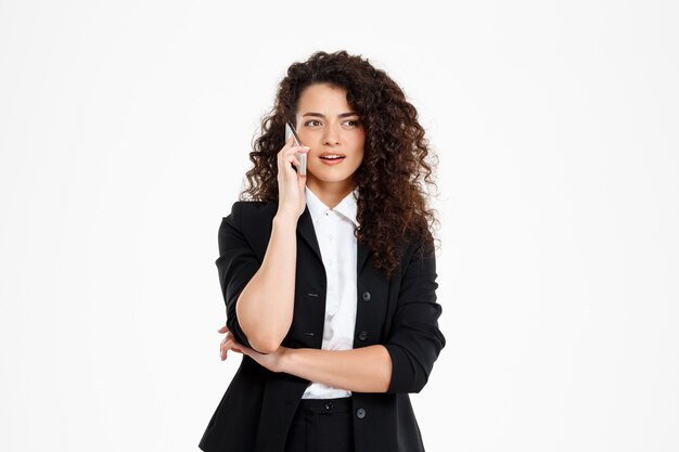  cheerful curly business girl talking on her phone