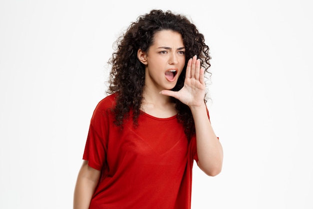 Free photo cheerful curly girl over white wall