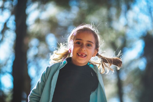 Cheerful cute girl in sunny forest