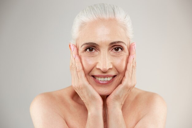 Cheerful cute naked elderly woman posing