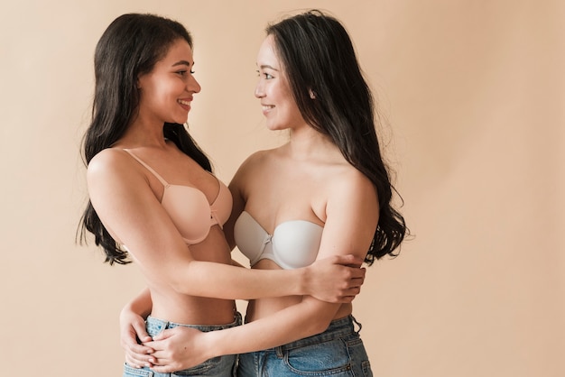 Cheerful diverse women in lingerie hugging