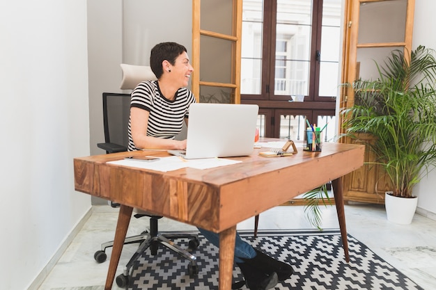 Free photo cheerful employee laughing in the office