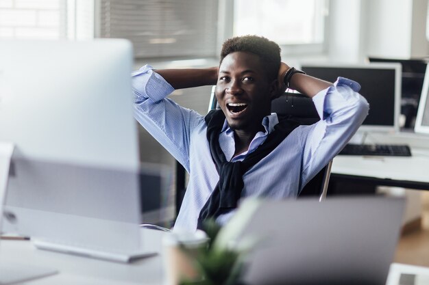 Cheerful entrepreneur at this office looking at monitor with a smile. Candid emotions.