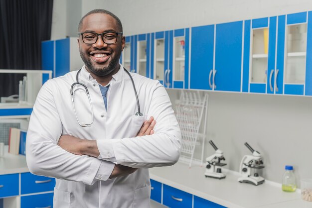 Cheerful ethnic doctor with arms crossed