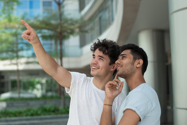 Cheerful excited guys dreaming together and looking up