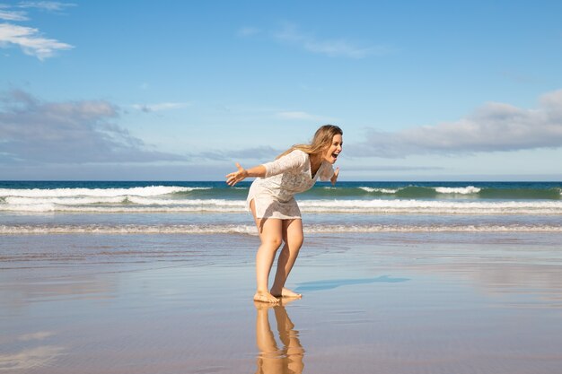 Cheerful excited woman bending and opening arms for catching and hugging child