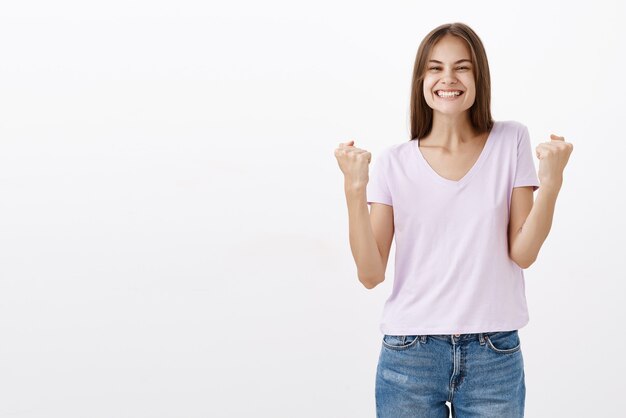 Cheerful excited woman raising fists and telling yes feeling happy and delighted with success and victory gesture