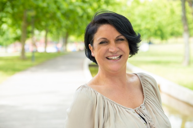 Cheerful excited woman walking in park