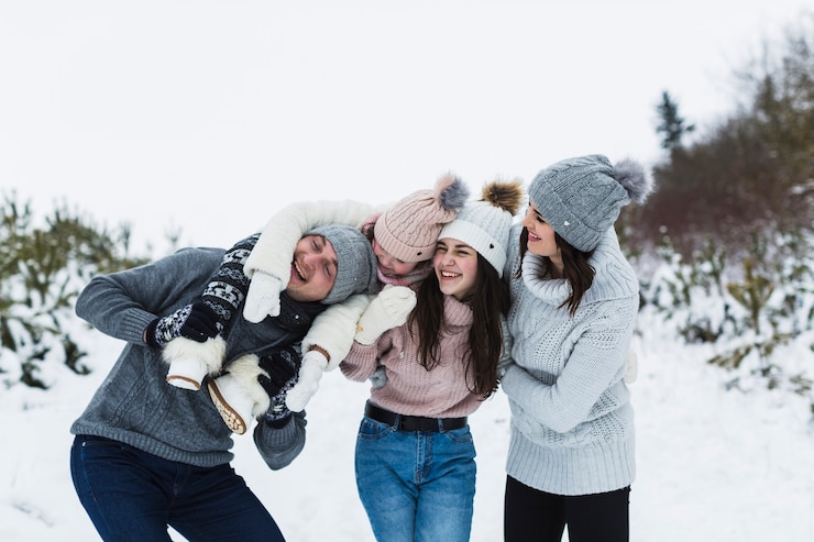 Free Photo cheerful family hugging in winter countryside