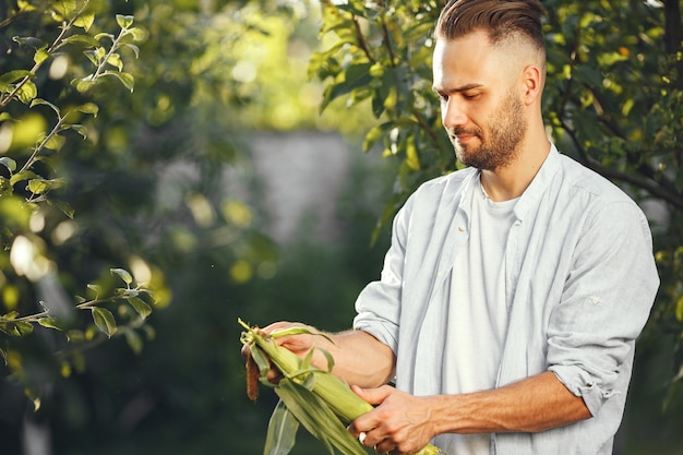 Foto gratuita allegro contadino con verdure biologiche in giardino. verdura biologica mista nelle mani dell'uomo.