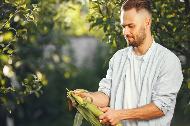 정원에서 유기농 야채와 쾌활 한 농부입니다. 남자의 손에 혼합 된 유기 야채입니다.