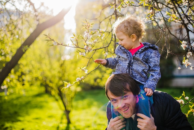 Cheerful father with his son on his shoulders