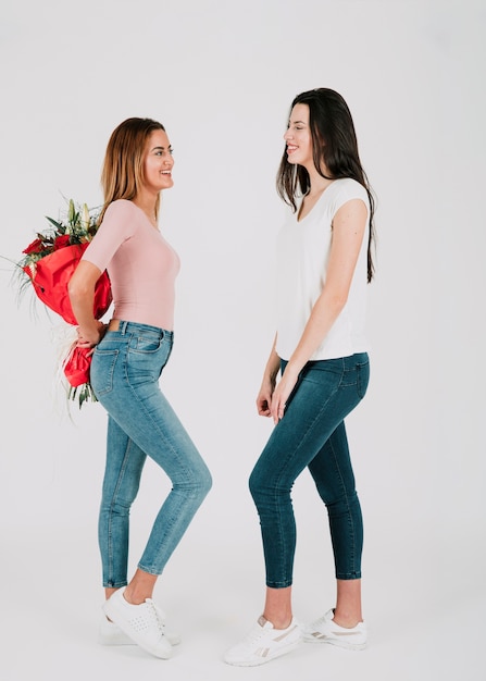 Cheerful female couple with bouquet