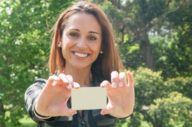 Cheerful female customer holding business card