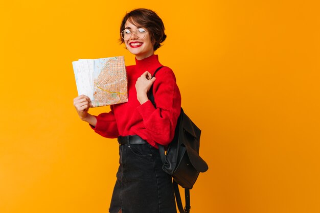 Cheerful female model holding city map