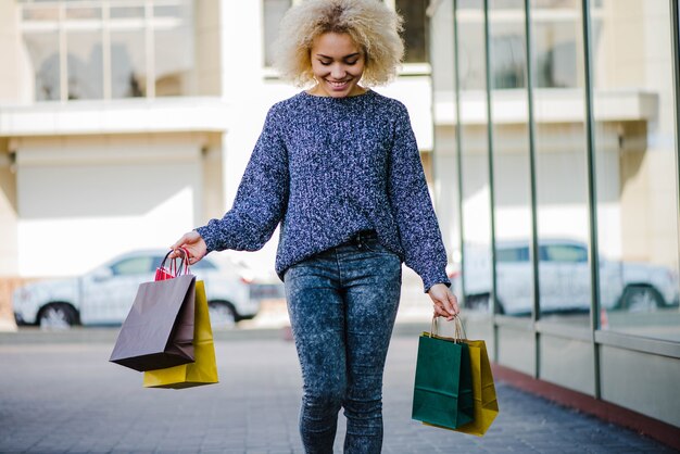 Cheerful female shopper walking