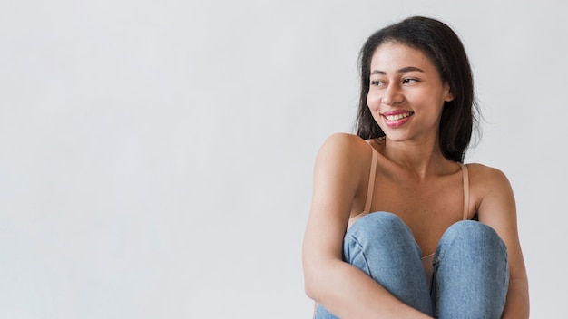 Seduta femminile allegra che distoglie lo sguardo