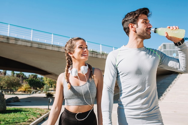 Cheerful fit woman and man outside