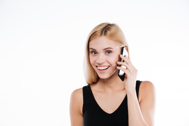 Cheerful fitness lady talking by mobile phone